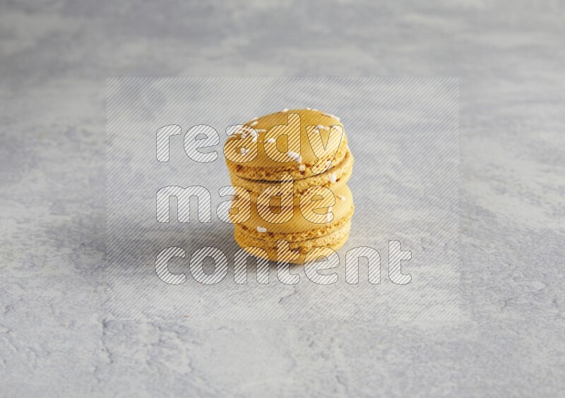 45º Shot of two Yellow Piña Colada macarons  on white  marble background