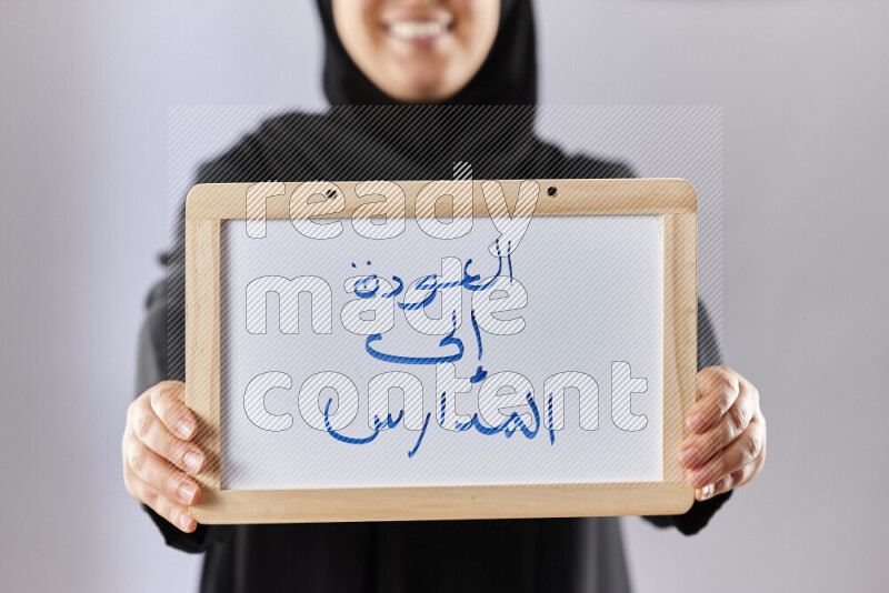 A woman in abaya holding books and a board in different positions (back to school)