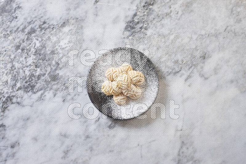 Kahk in black pottery plate on grey marble background