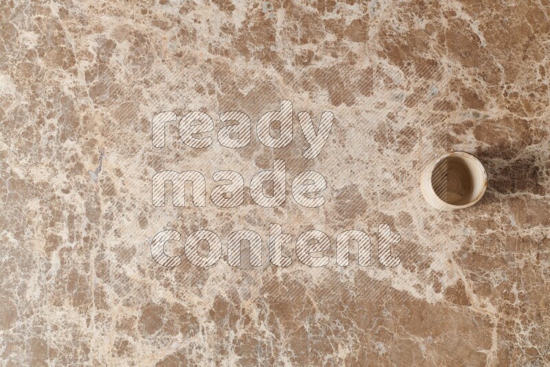 A pottery cup on beige marble background