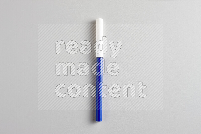 A close-up showing a single coloring pen with a cap on grey background