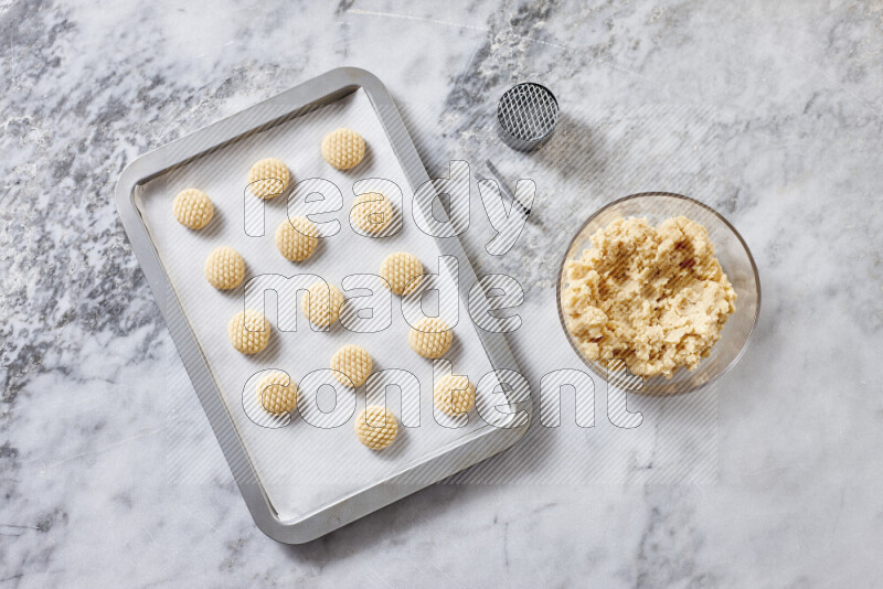 Kahk step by step with its ingredients ghee, sugar, flour, sesame, yeast, water and kahk flavor on grey marble background