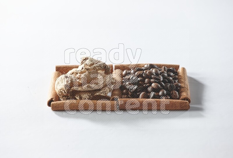 2 squares of cinnamon sticks full of coffee beans and dried ginger on white flooring