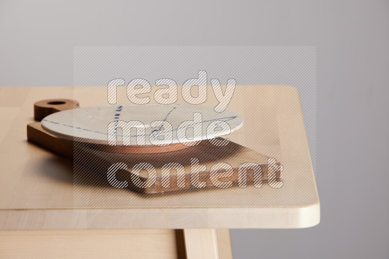 multi-colored pottery Plate placed on a  wooden rectangular cutting board on the edge of wooden table