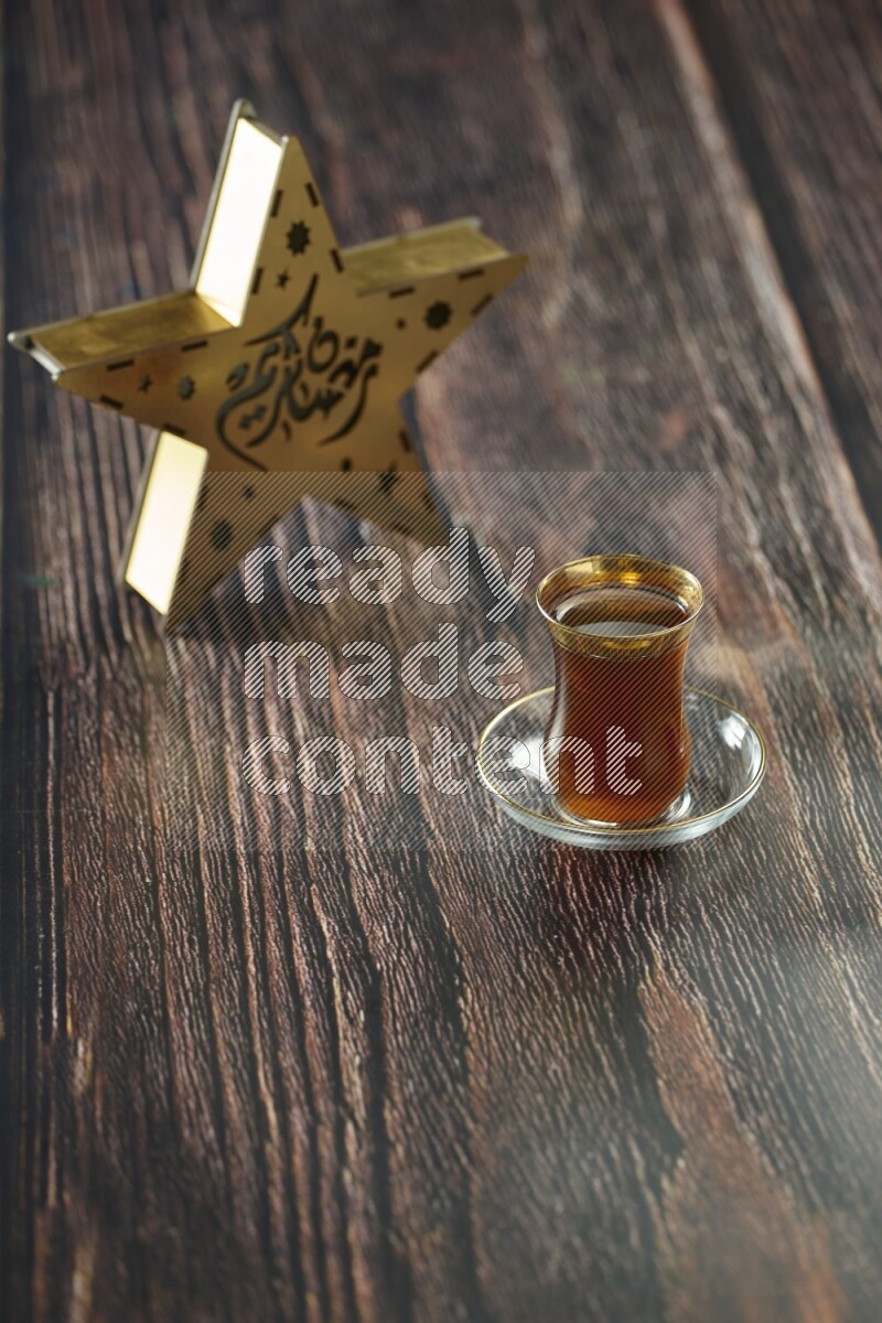 A wooden golden star lantern with different drinks, dates, nuts, prayer beads and quran on brown wooden background