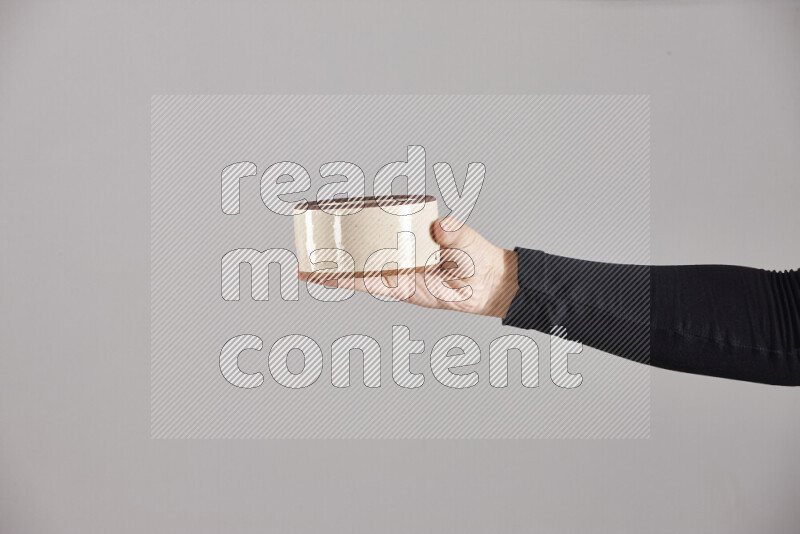 A woman in black abaya holding different pottery essentials in different positions