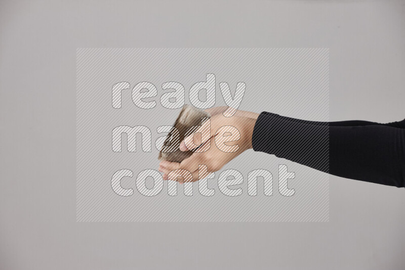 A woman in black abaya holding different pottery essentials in different positions