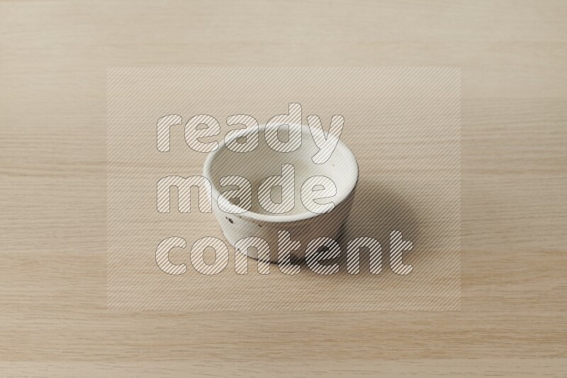 A white pottery bowl on light wooden background