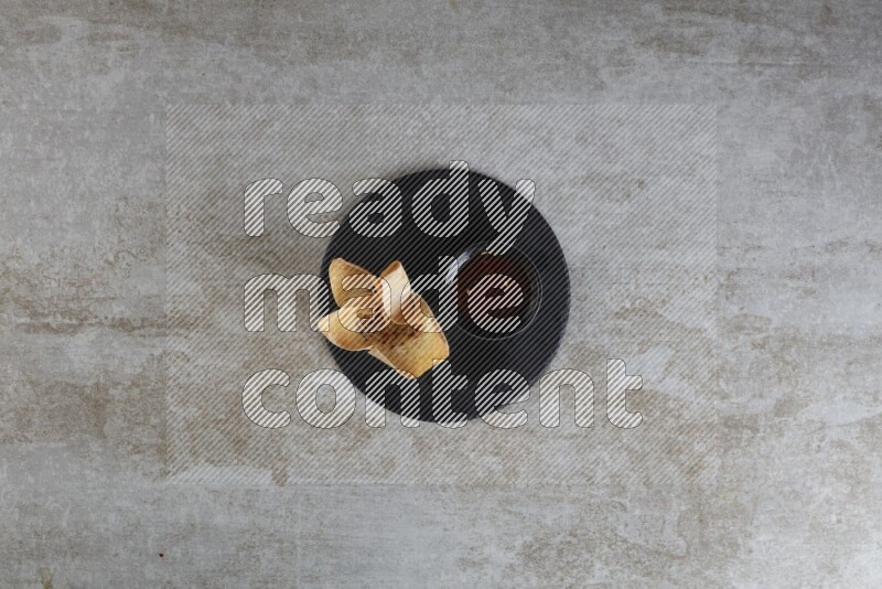 wonton cups with soy sauce ramkin on circle slate on grey textured counter top