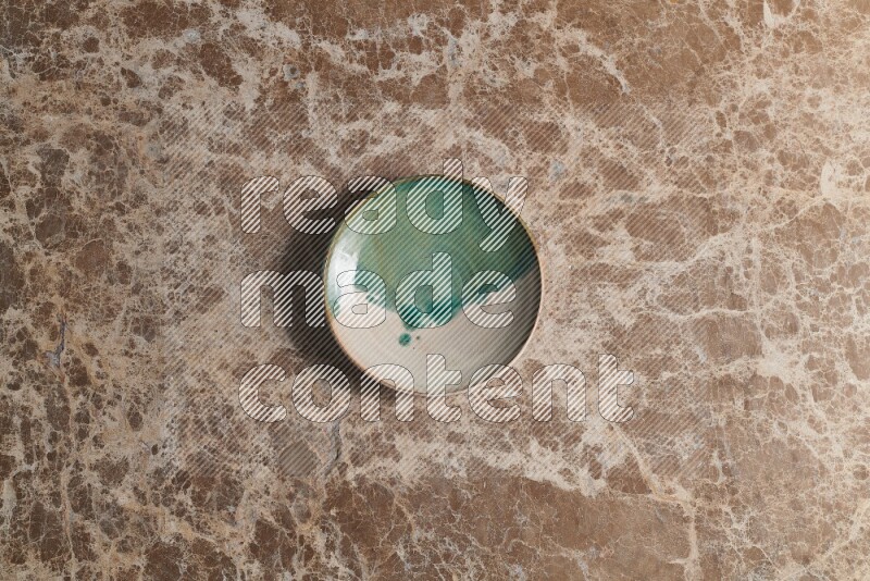 A decorative pottery plate on beige marble background