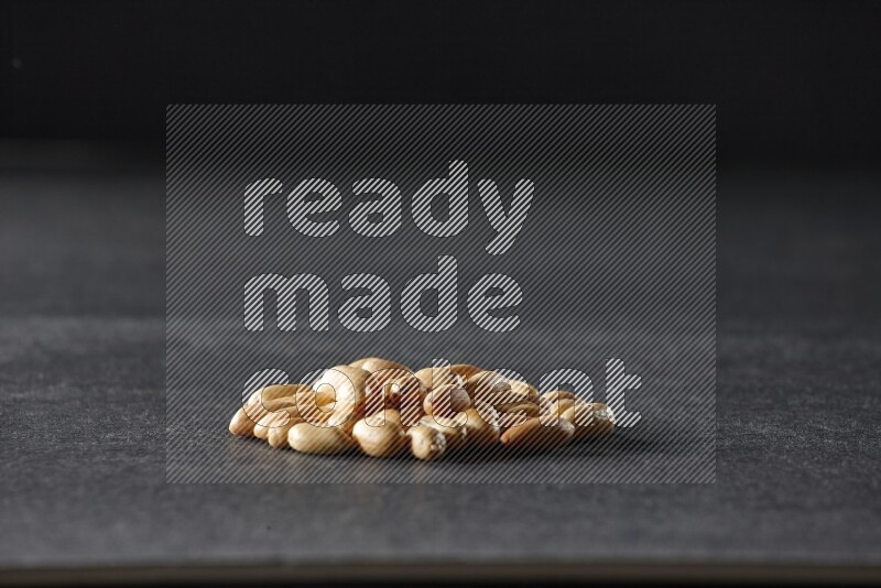 A bunch of peeled peanuts on a black background in different angles