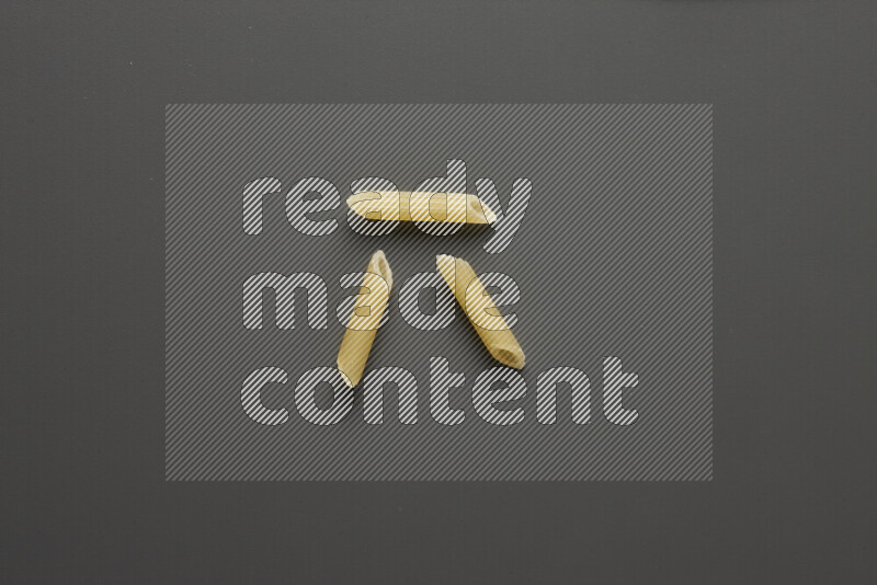 Mini penne pasta on grey background