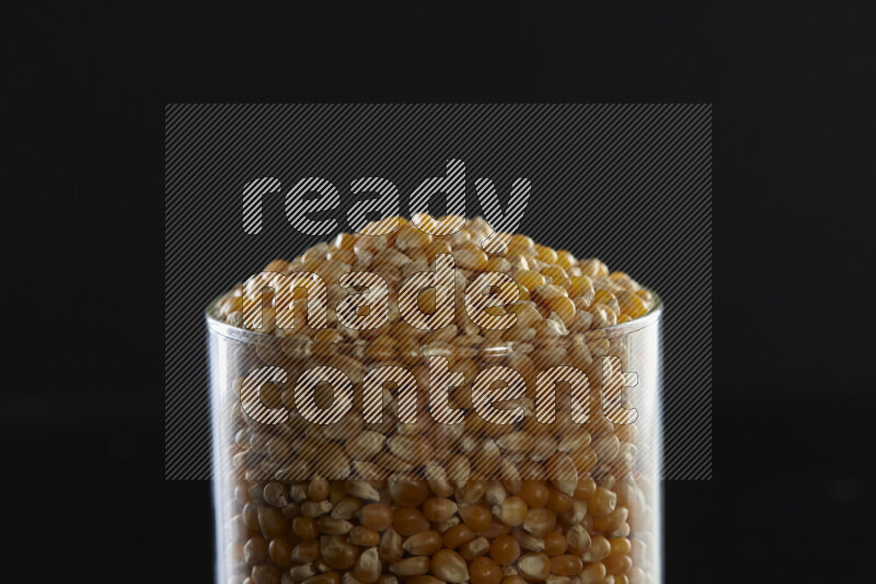 Pop corn in a glass jar on black background