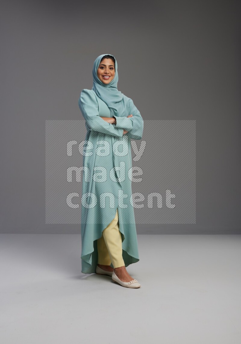 Saudi Woman wearing Abaya standing with crossed arms on Gray background