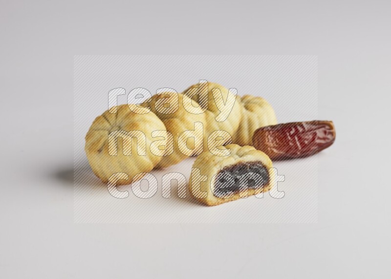 Five Pieces of Maamoul filled with date one of them is cut direct on white background