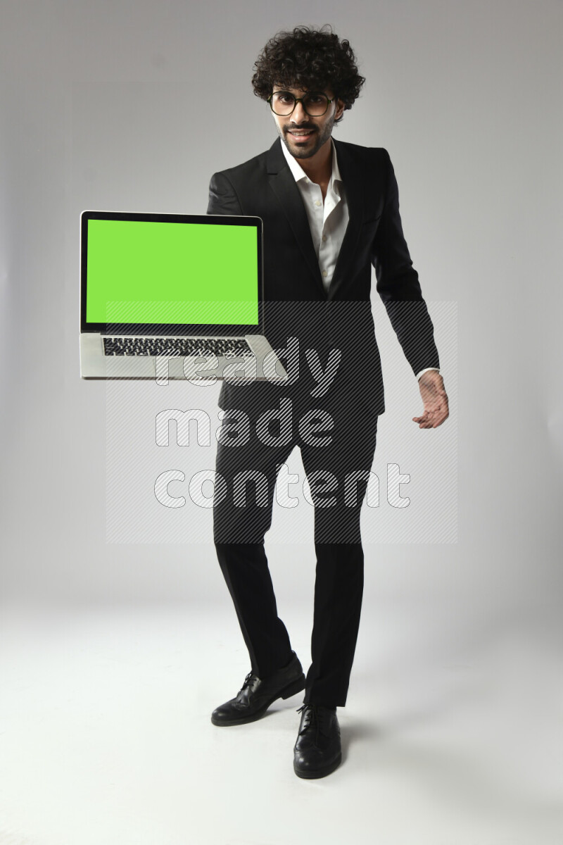 A man wearing formal standing and showing a laptop screen on white background