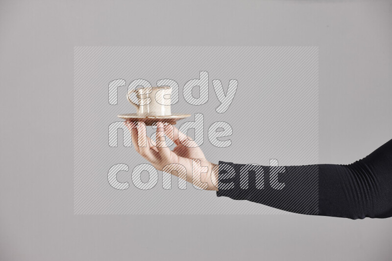 A woman in black abaya holding different pottery essentials in different positions
