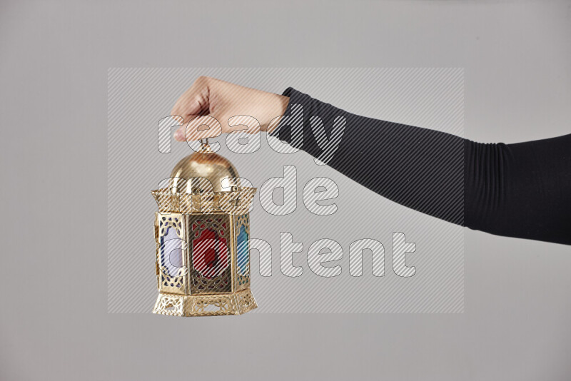 A woman in black abaya holding different ramadan lanterns in different positions