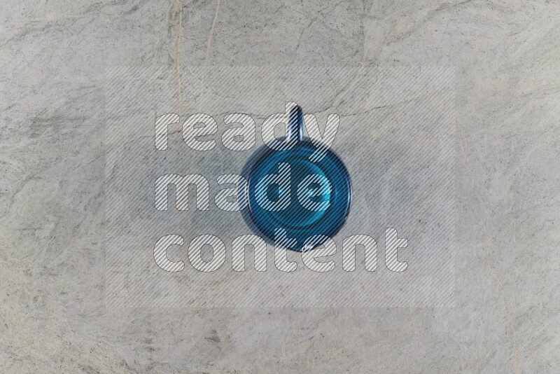 A colored glass jug on grey marble background