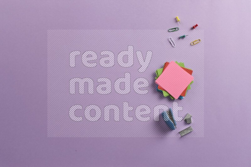 ورق ملاحظات متعدد الألوان مع مستلزمات مدرسية على خلفية أرجوانية