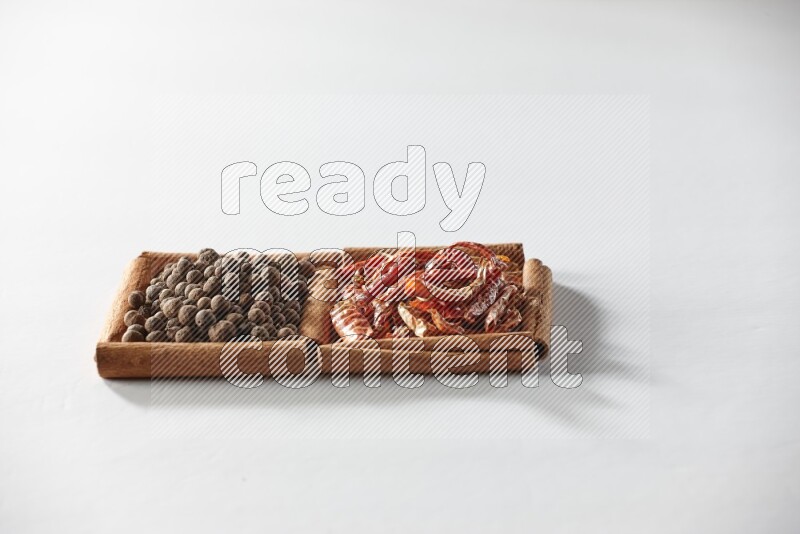 2 squares of cinnamon sticks full of dried red chilis and allspice on white flooring