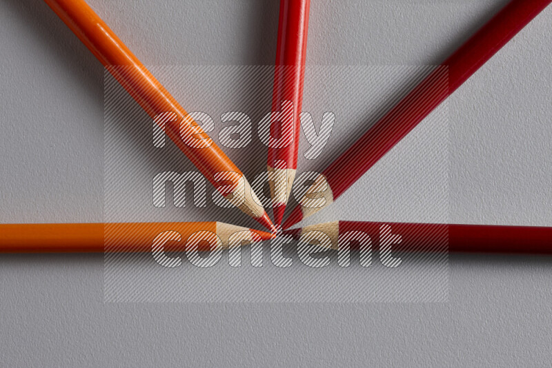 An arrangement of colored pencils in different colors on grey background