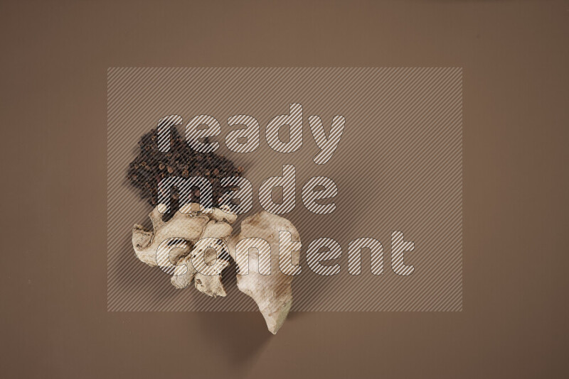 بهارات كاملة متنوعة تتضمن زنجبيل طازج ومجفف، أعواد قرفة، هيل، أصابع كركم، قرنفل، يانسون نجمي على خلفية بيج