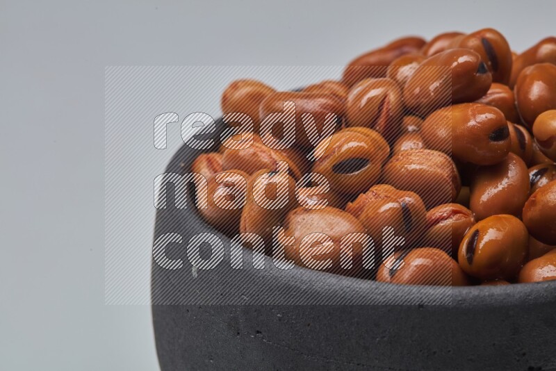 Close up shot of cooked fava beans (foul) in a container on white background