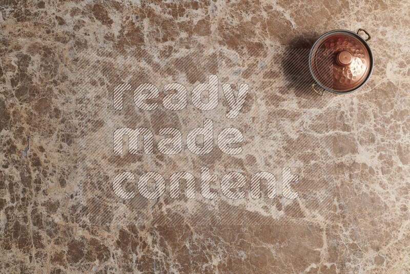 وعاء نحاسي صغير على خلفية من الرخام البيج