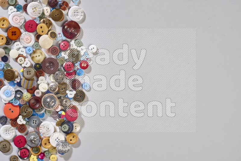 Mixed assorted buttons on grey background