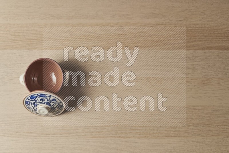 A multicolored pottery pot on light wooden background