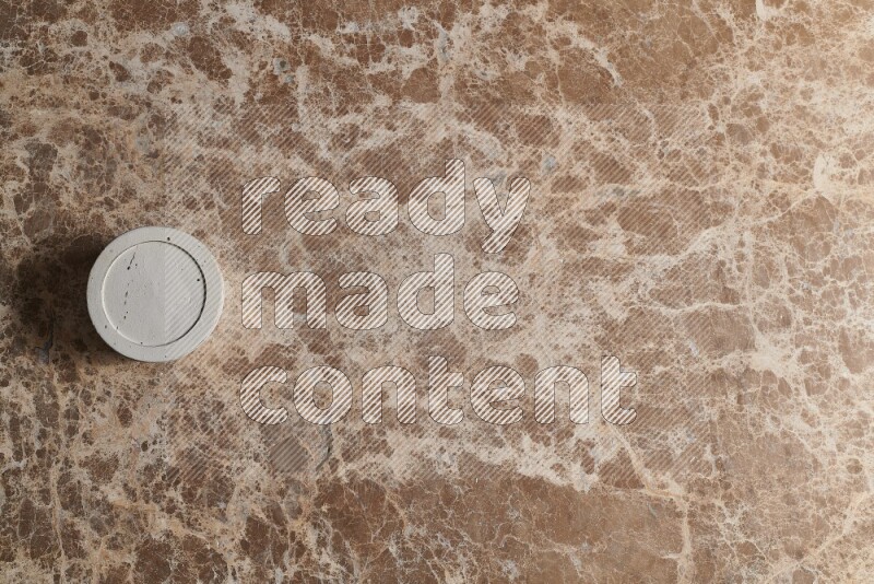 A pottery cup on beige marble background