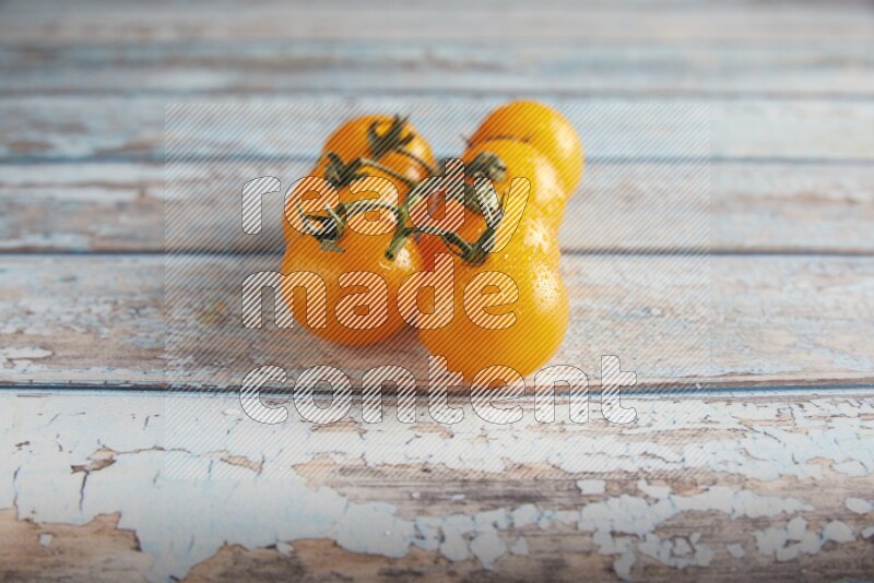 yellow cherry tomato vein on a textured blue wooden background 45 degree