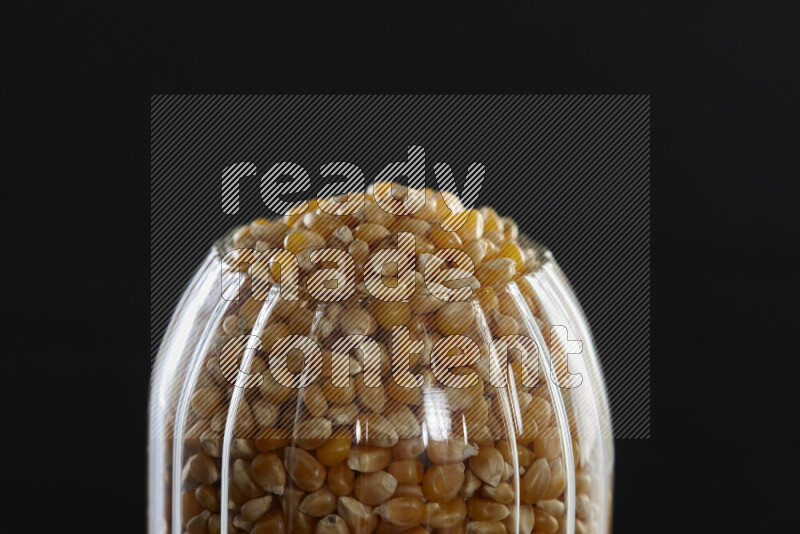 Pop corn in a glass jar on black background