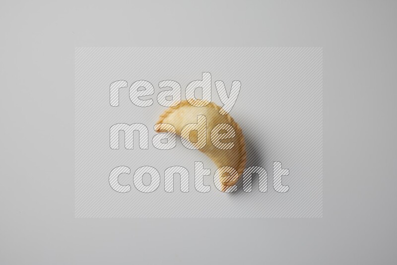 One fried sambosa from a top angle on a white background