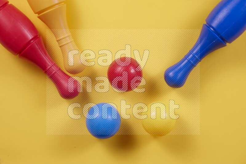 Plastic bowling pins with balls on different colored backgrounds (kids toys)