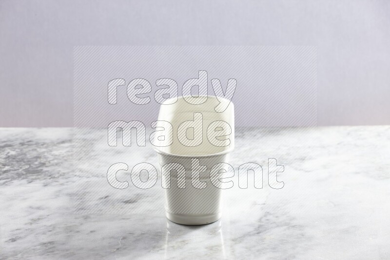 An empty white plant pot on grey marble background