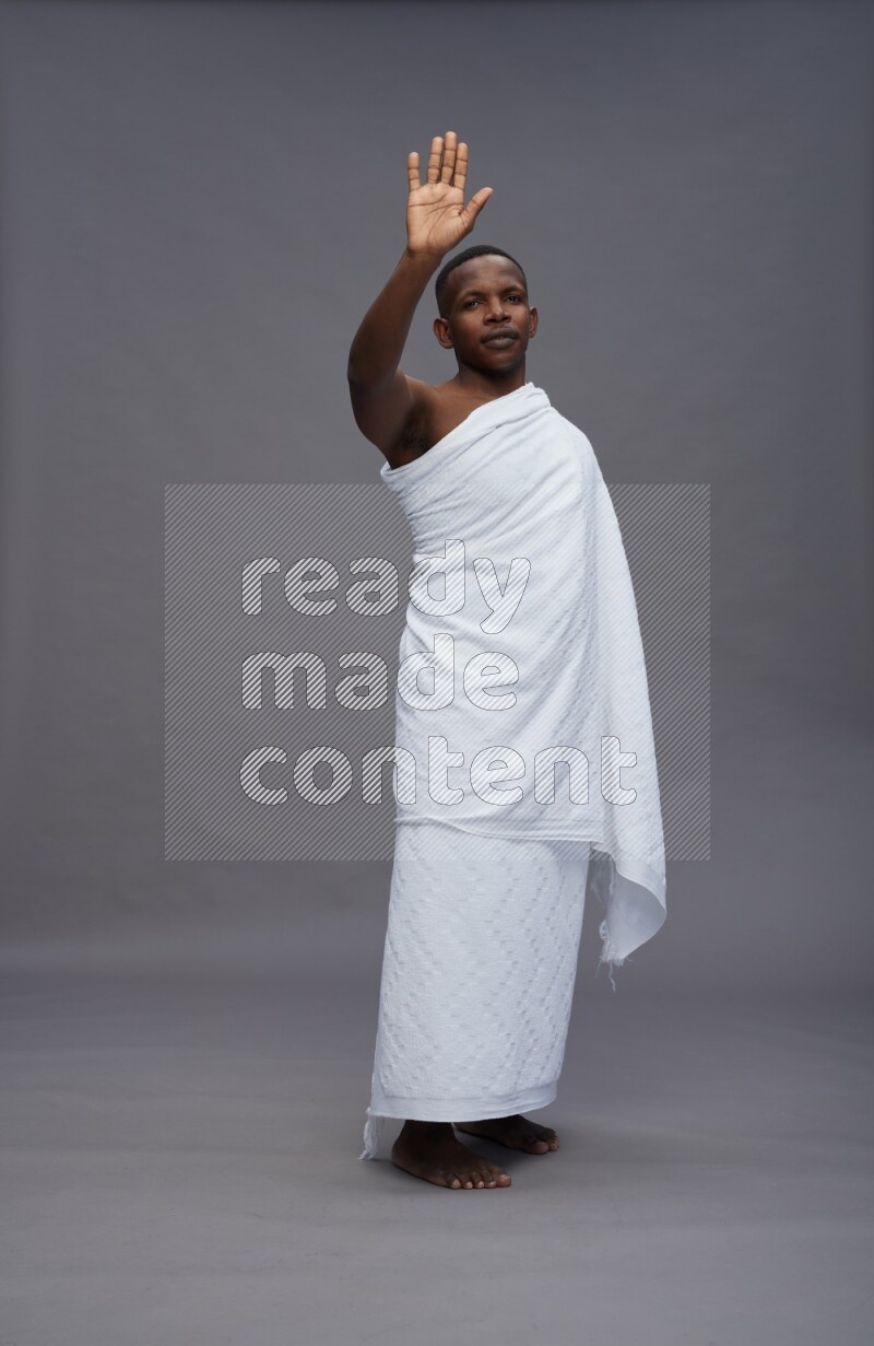 A man wearing Ehram Standing Interacting with the camera on gray background