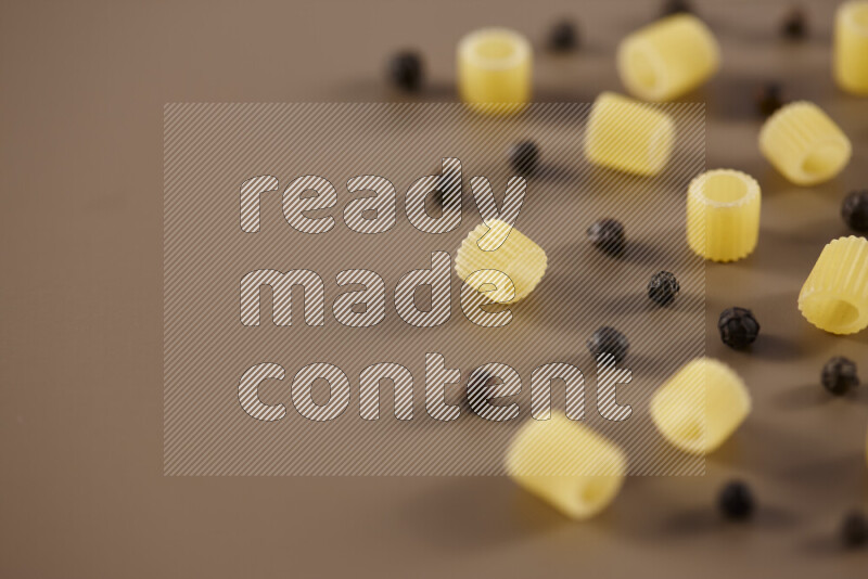 معكرونة مع مكونات متنوعة من الطماطم والثوم والبصل والفلفل الأحمر والفلفل الأسود والفلفل الأبيض وأوراق الغار وإكليل الجبل والهيل على خلفية بيج