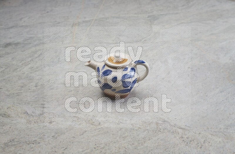 A pottery teapot on grey marble background
