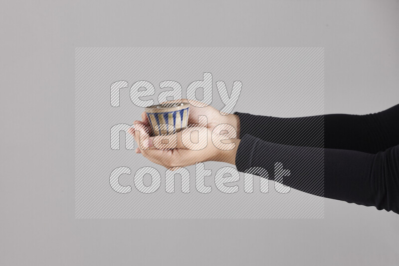 A woman in black abaya holding different pottery essentials in different positions