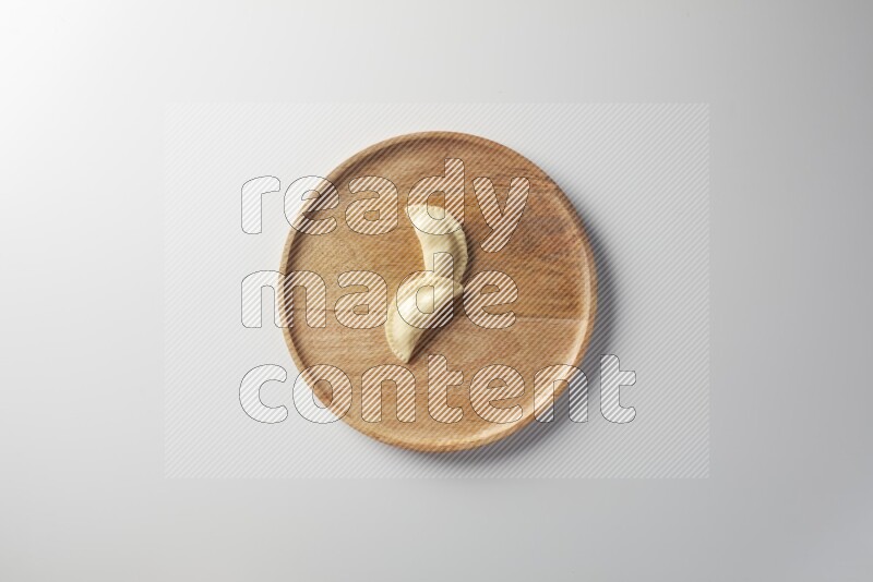 Two Sambosas on a wooden round plate on a white background