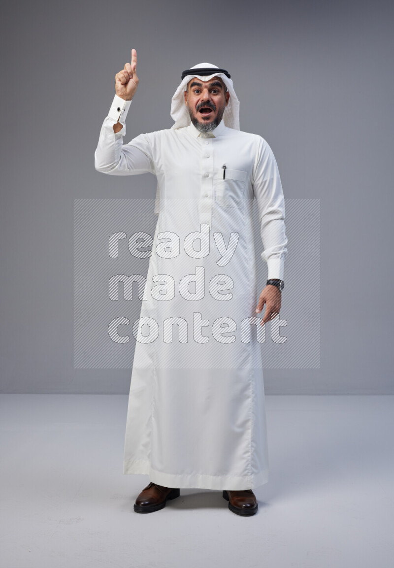 رجل سعودي يرتدي ثوب وشماغ ابيض يتفاعل امام الكاميرا