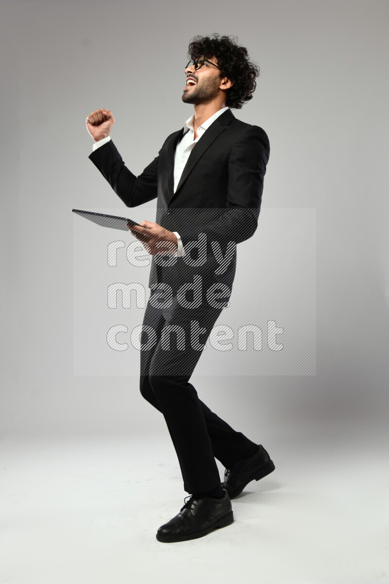 رجل يرتدي ملابس رسمية يلعب علي تابلت علي خلفية بيضاء