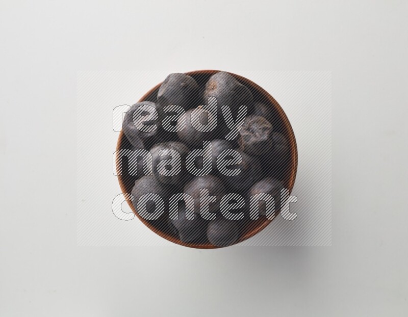 Top-view shot of dried lime (loomi) in a container on white background