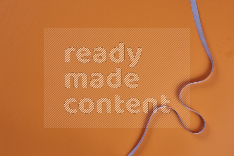 A purple collection of sewing and tailoring tools arranged on a orange background