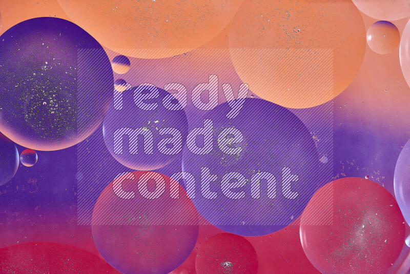 Close-ups of abstract oil bubbles on water surface in shades of red, orange and purple