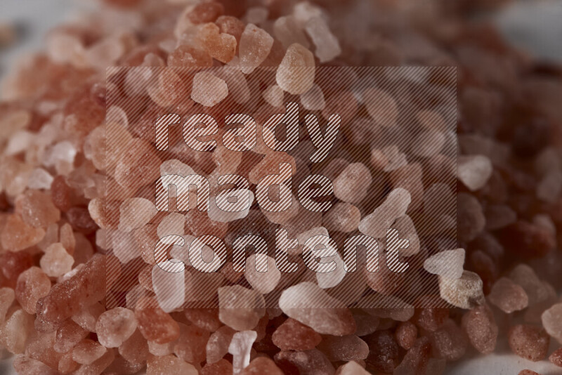 A bunch of coarse himalayan salt crystals on white background