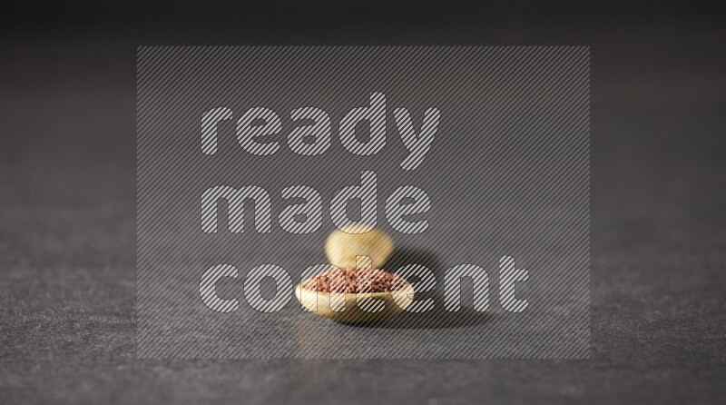 ملعقة خشبية ممتلئة ببذور حب الرشاد علي خلفية سوداء