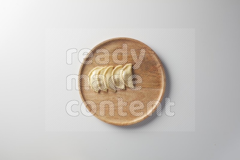 Five Sambosas on a wooden round plate on a white background